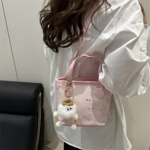 Sac seau rose imprimé papillon avec breloque peluche sur fond de chemise blanche