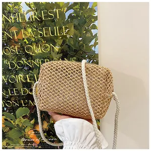 Detail van de strooien crossbodytas met een dikke witte gevlochten touw schouderband