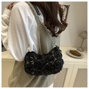 Detail of elegant black lace evening clutch with 3D flower pattern and chain strap