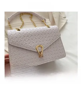 Detail of white PU leather bag with woven texture, gold chain and geometric metal clasp