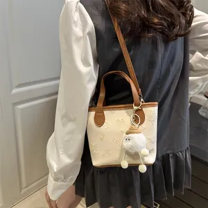 Sac seau chic crème avec gaufrage papillon et pendentif boule en peluche douce