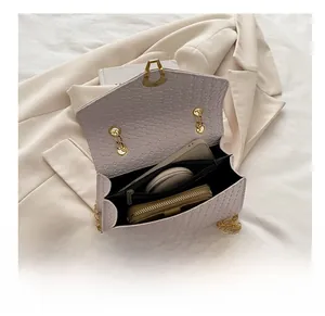 Macro detail of the light purple faux crocodile leather bag showing internal storage
