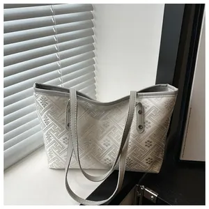 Detailaufnahme von Jacquard-Stoff mit grauen Blumenmustern auf einer Tragetasche