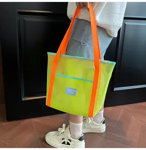 Detail of mesh beach tote with neon yellow grid and vibrant orange strap handles