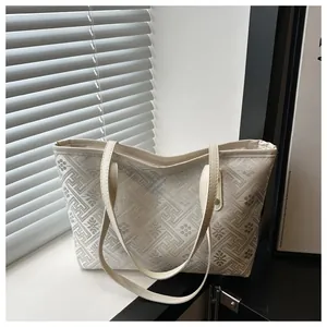 Detailaufnahme des chinesischen Stickmusters auf der cremefarbenen Beuteltasche