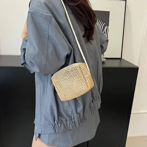 Handgemaakte geweven crossbodytas in beige met witte touwband gedragen door model