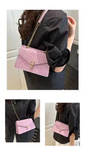 Detail of purple woven PU leather shoulder bag with gold metal clasp and chain strap