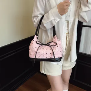 Sac à bandoulière rose à motif nœuds avec poignées en cuir noir et nœud central