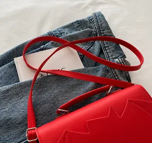 Détails du sac à main rouge en similicuir avec coutures en étoile et bandoulière réglable