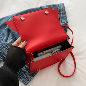 Vue intérieure du sac à main rouge en similicuir montrant la capacité de rangement