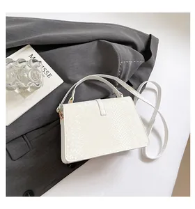 Gros plan sur la texture gaufrée serpent crème de ce sac à main carré élégant et moderne