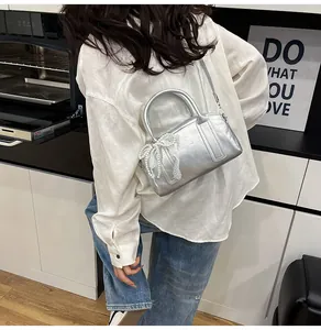 Sac Boston argenté avec nœud en dentelle et perles porté en bandoulière