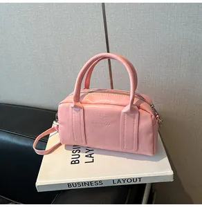Detailed shot of pink Boston handbag showing soft PU leather and embossed lettering logo