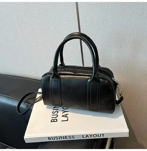 Detail of black Boston bag featuring embossed English lettering and dual handle design