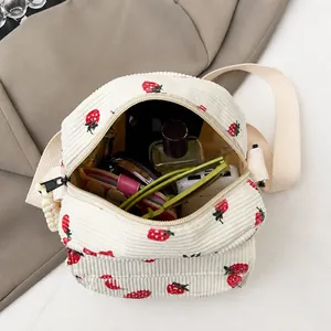 Internal capacity of white corduroy crossbody bag with cute red strawberry print