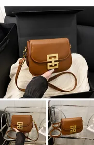 Detailansicht braune Satteltasche aus Leder mit goldener Schnalle und Schultergurt
