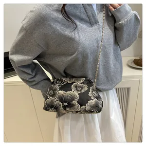 Mini floral embroidered handbag with vintage metal clasp and gold chain strap on model