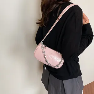 Detail of light pink patent leather small square bag with silver chain and logo