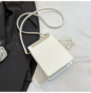 Détail du sac bandoulière blanc en cuir PU avec bordure tressée jaune et boucles dorées
