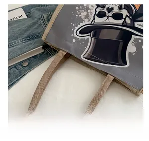 Close-up of durable woven handle and skull graphic print on canvas tote bag
