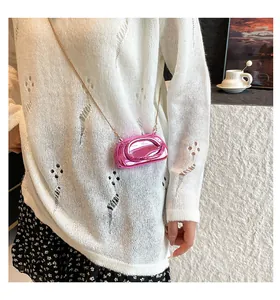 Vue détaillée d'un sac à bandoulière rigide rose métallisé avec une chaîne dorée