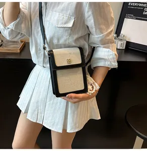 Détail du sac de téléphone en toile crème et cuir noir avec un design de patchwork chic