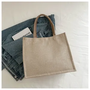 Detail of the high-quality beige burlap tote bag texture and reinforced stitched handles