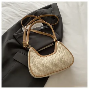 Detail of woven hobo bag with brown leather trim and golden metal zipper hardware