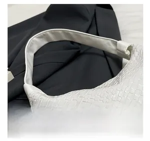Close-up of white woven leather texture on a minimalist large capacity tote bag