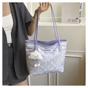 Detail of purple tote bag with intricate embroidery and white cloud plush charm