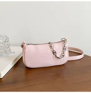 Detail of pink pleated PU underarm bag featuring silver chain and leather shoulder strap