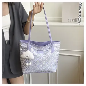 Detail of purple tote bag with geometric pattern and plush white cloud charm accessory