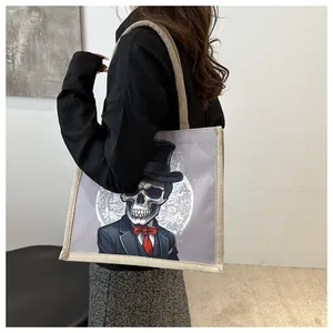 Detail of canvas tote bag showing top handle texture and gentleman skull print pattern