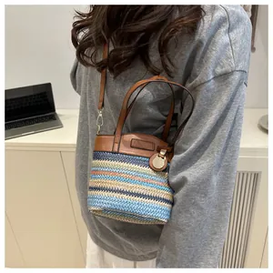 Detail der farblich abgesetzten Webhandtasche mit Lederbesatz und Eulenanhänger