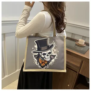 Lifestyle shot of a grey canvas tote bag with a gentleman skull print and jute trim