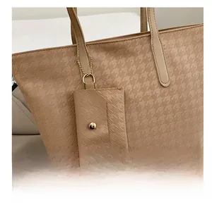 Detail showing beige houndstooth tote bag texture with chain mini coin purse attachment