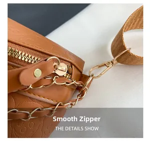 Detailed macro view of smooth golden metal zipper on embossed skull pattern chest bag