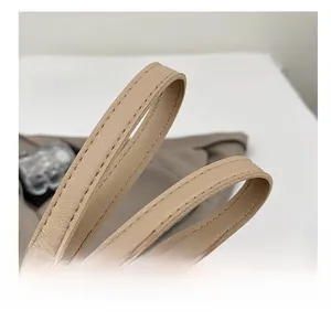 Close-up of beige litchi grain leather shoulder strap with neat stitching details
