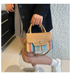 Detail of a chic two-tone handbag featuring khaki leather and colorful woven fabric