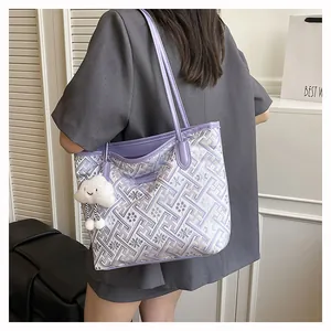Detail of purple geometric floral tote bag with plush cloud charm and leather straps