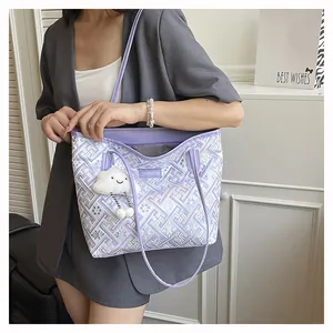 Detail of purple tote bag with ethnic patterns and cloud charm in indoor setting