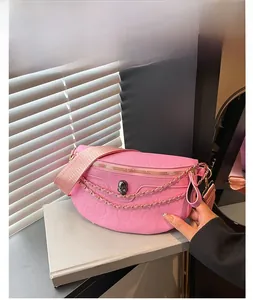 Detailed macro of pink PU leather crescent bag featuring skull embossing and metal chains