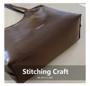 Détail d'un sac cabas marron foncé montrant le cuir PU lisse et les surpiqûres de précision