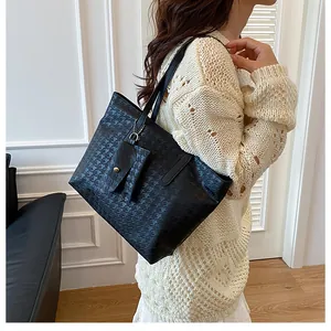 Detail of black houndstooth tote bag with matching accessory pouch on a model