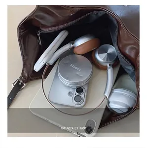Intérieur spacieux du cabas marron foncé avec ordinateur, casque et objets du quotidien