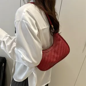 Red woven leather shoulder bag with crescent shape and minimalist hobo style for women