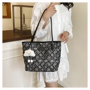 Detail of black and white geometric pattern tote bag with white cloud plush charm
