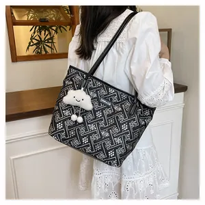 Detail of printed tote bag with maze pattern and cute plush cloud charm on model