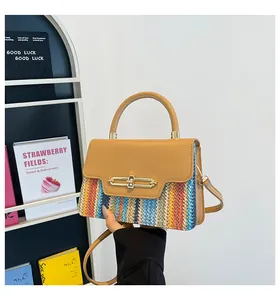 Detail of color-block woven handbag with caramel leather flap and gold twist-lock closure