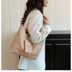 Detail of beige woven texture tote bag and matching mini pouch on white blazer